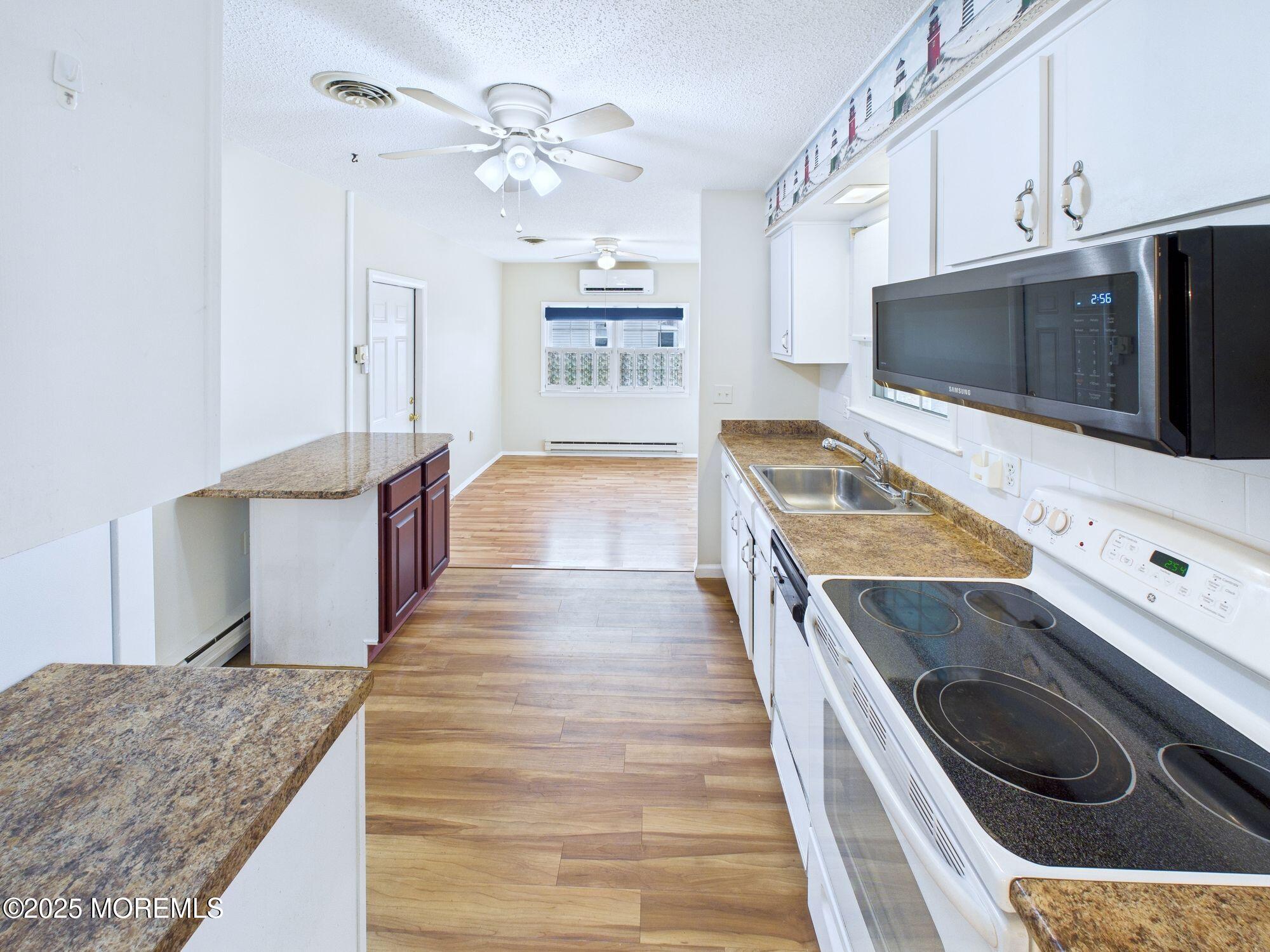 10 Hartford Road Manchester Township, NJ 08759 - Photo 16 of 35 a view of a kitchen with kitchen island a sink a stove and wooden floor