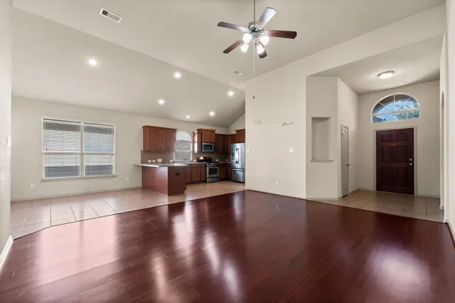 a view of a livingroom with furniture wooden floor and a kitchen