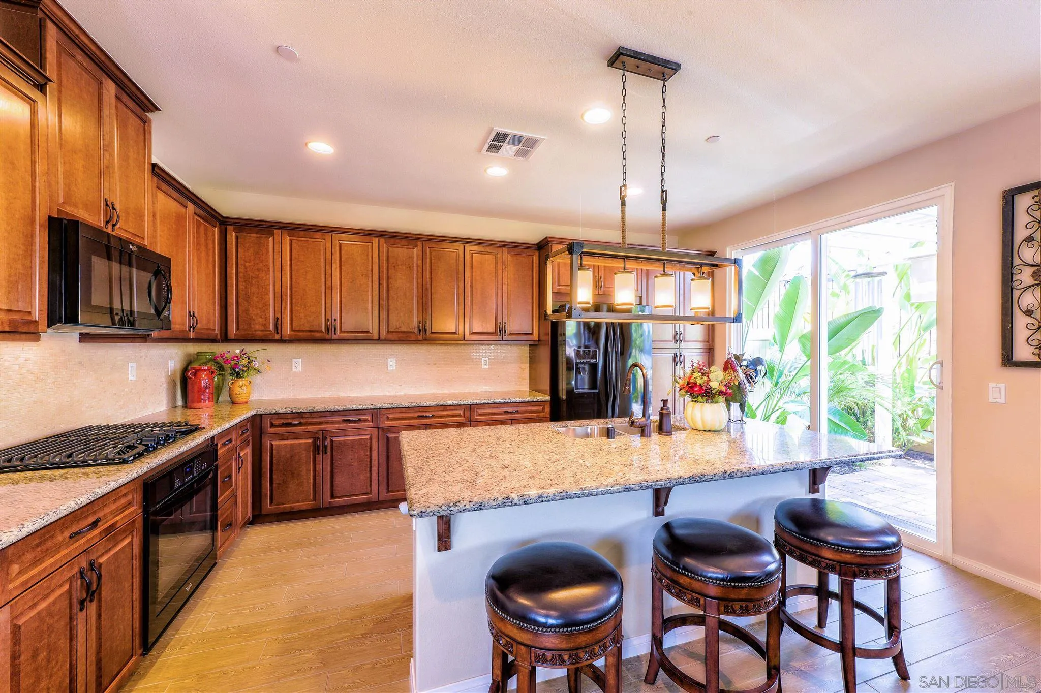 8629 Orchard Bloom Way El Cajon, CA 92021 - Photo 6 of 19 a kitchen with granite countertop lots of wooden cabinets stainless steel appliances a window and dining table