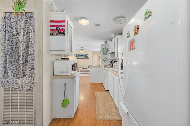 a kitchen with stainless steel appliances a white refrigerator a stove top oven a sink and dishwasher