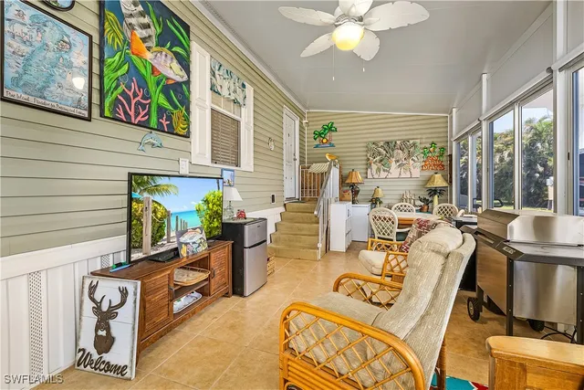 a living room with furniture a flat screen tv and a large window