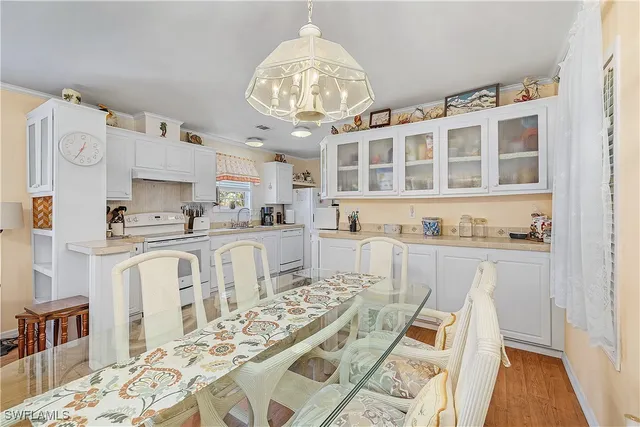 a view of a kitchen with granite countertop a white cabinets and chairs