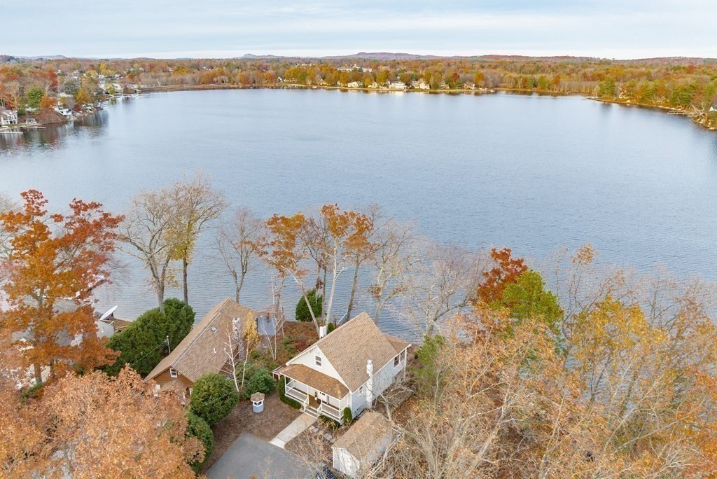 an aerial view of ocean and residential houses with outdoor space
