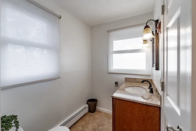 a bathroom with a granite countertop sink vanity mirror and window