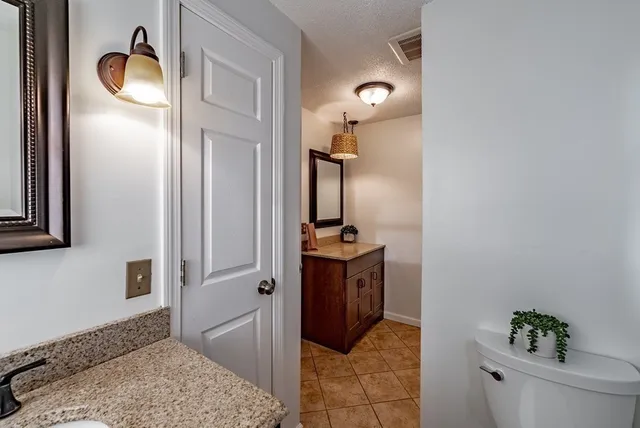 a en suite bathroom with a granite countertop sink and a mirror