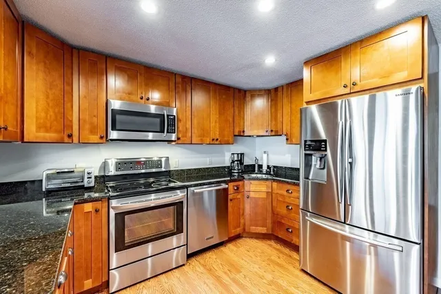 a kitchen with stainless steel appliances granite countertop a refrigerator stove top oven a sink and dishwasher
