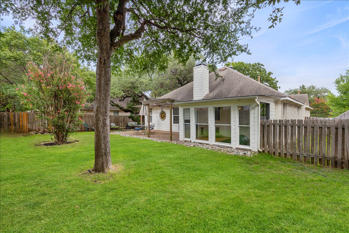 9012 Meacham Way Austin, TX 78749 - Photo 30 of 34 Expansive backyard featuring a lush lawn and mature trees