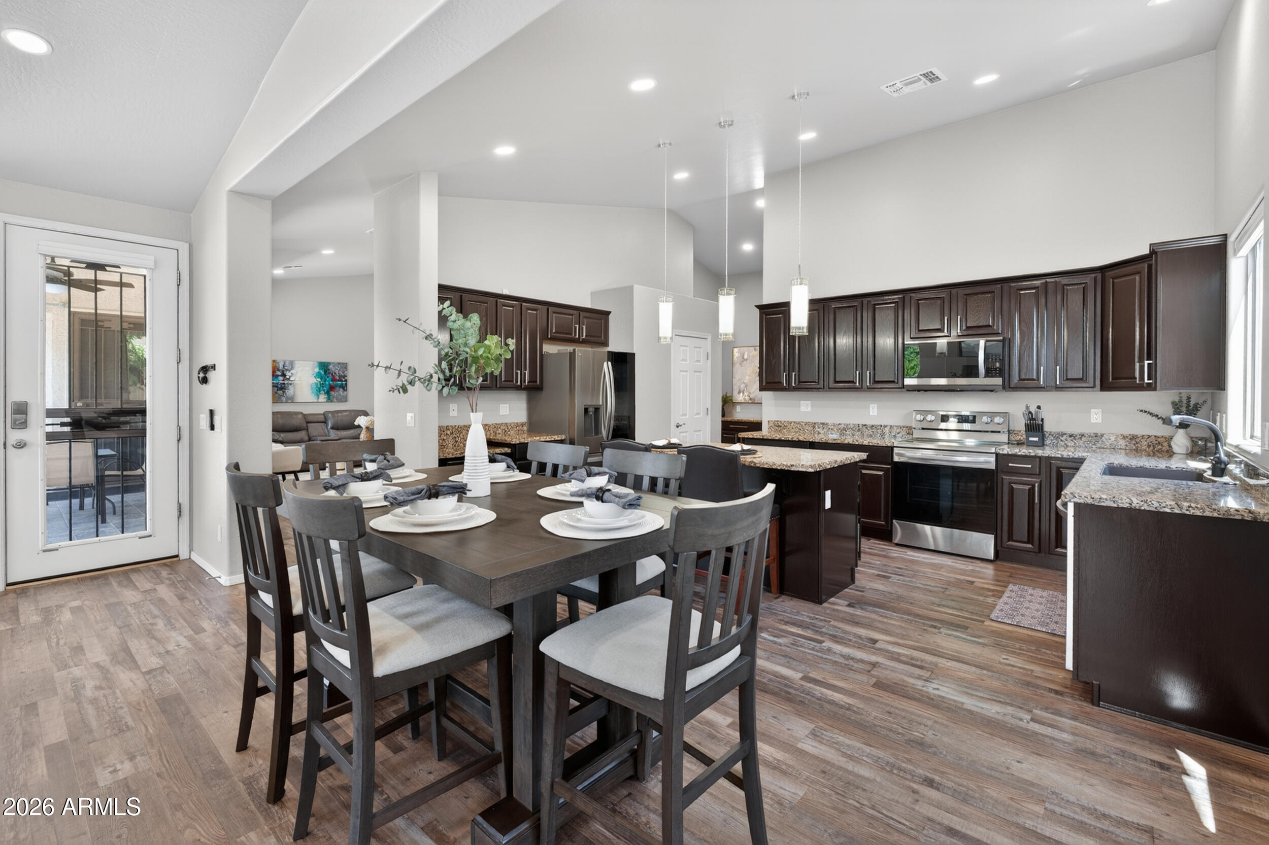 625 West Merrill Avenue Gilbert, AZ 85233 - Photo 8 of 48 a kitchen with stainless steel appliances kitchen island granite countertop a sink a stove a dining table and chairs