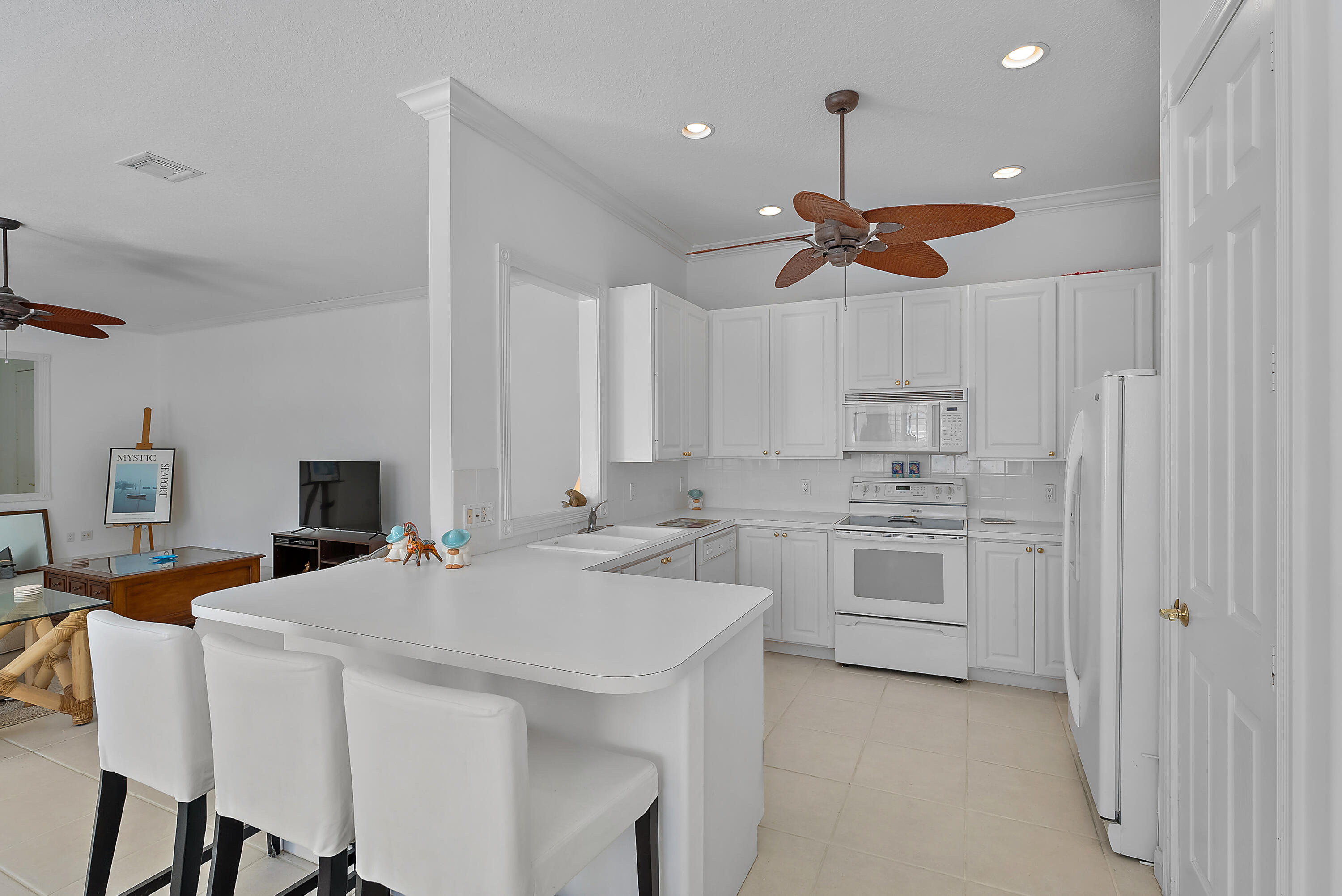 213 Barbados Drive Jupiter, FL 33458 - Photo 15 of 55 a kitchen with a white cabinets appliances and chandelier