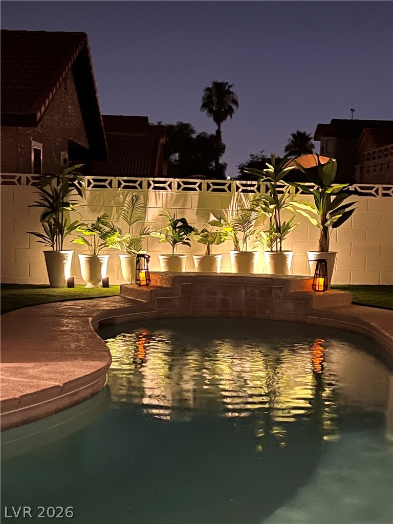6505 Deadwood Road Las Vegas, NV 89108 - Photo 29 of 33 An inviting backyard oasis offers a sparkling pool and charming patio area, perfect for nighttime enjoyment.