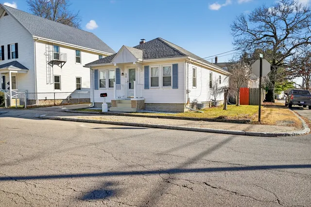 a view of a white house with a swimming pool table and chairs