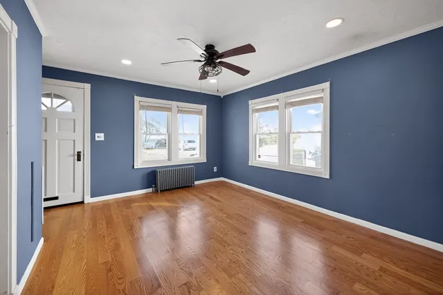 a view of a livingroom with a window and wooden floor