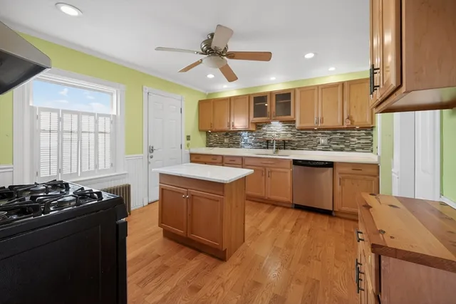 a kitchen with stainless steel appliances kitchen island granite countertop a stove a sink dishwasher and a refrigerator