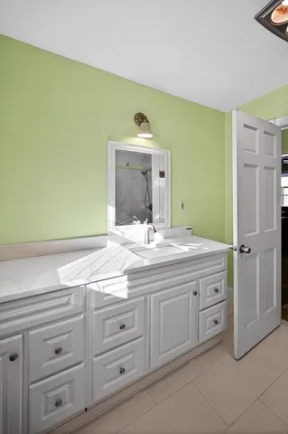 a bathroom with a granite countertop sink and a mirror