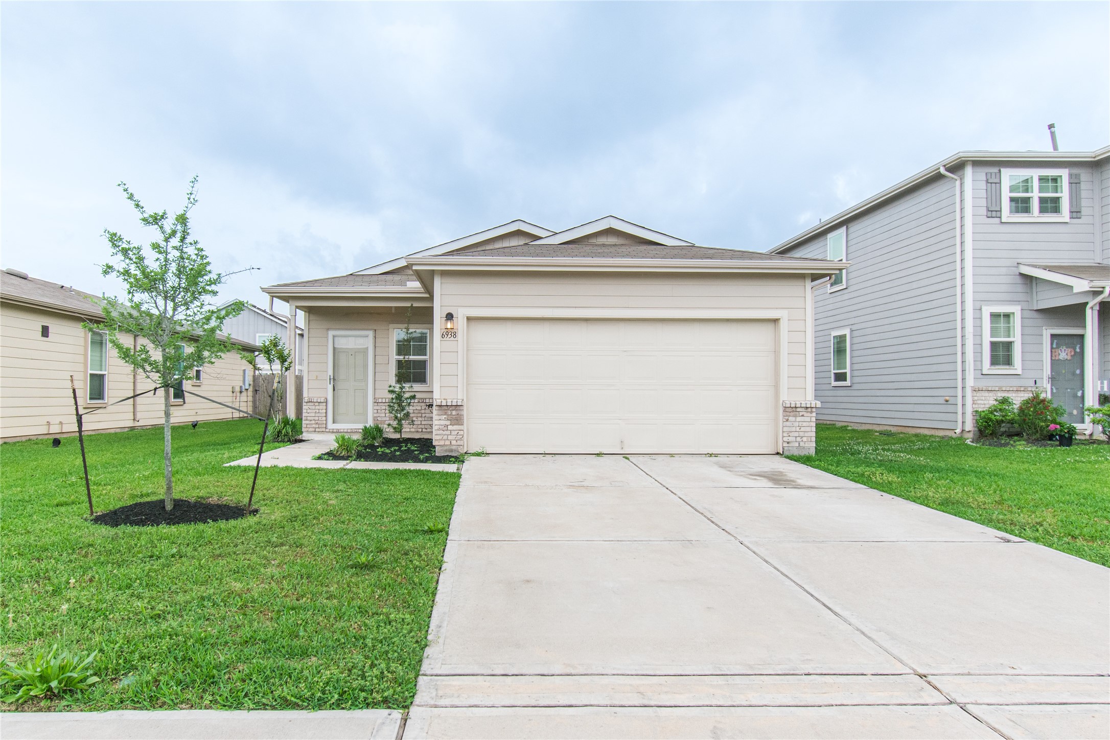 6938 Hobby Wind Ridge Drive Houston, TX 77075 - Photo 2 of 30 a front view of a house with a yard and garage