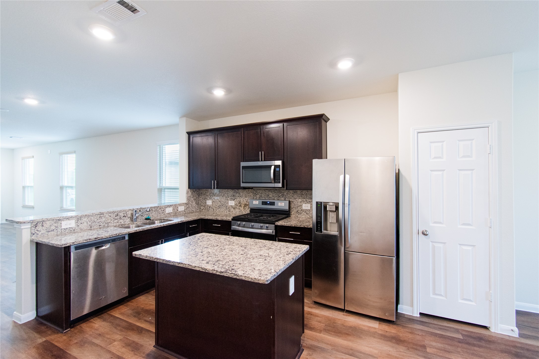 6938 Hobby Wind Ridge Drive Houston, TX 77075 - Photo 4 of 30 a kitchen with granite countertop kitchen island stainless steel appliances a refrigerator sink stove microwave and cabinets