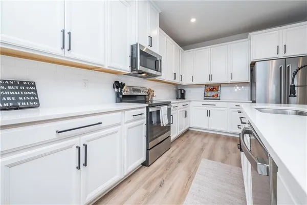 a kitchen with cabinets stainless steel appliances and sink