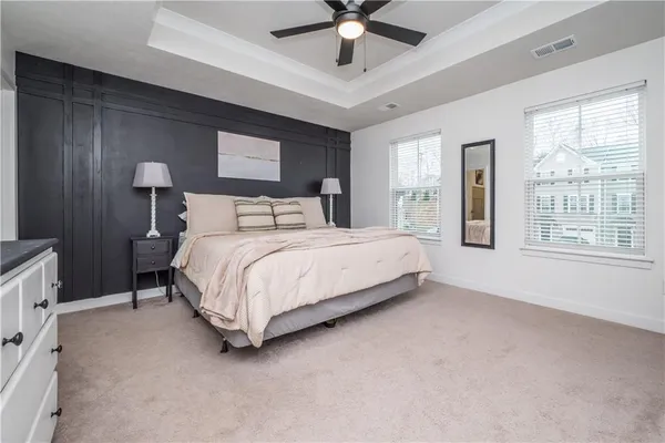 a bedroom with a large bed chandelier and a window