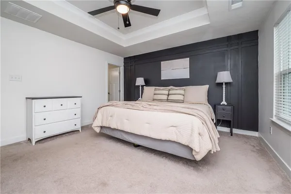 a bedroom with a bed and a ceiling fan