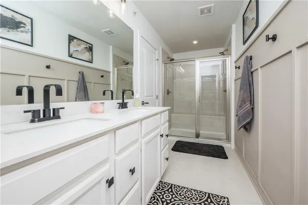 a bathroom with a sink a toilet a mirror and shower