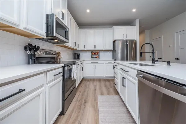 a kitchen with stainless steel appliances granite countertop a sink and a stove