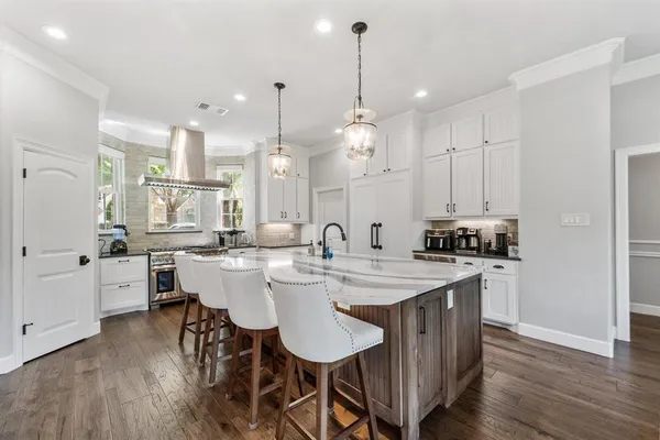 a large kitchen with kitchen island a sink table and chairs