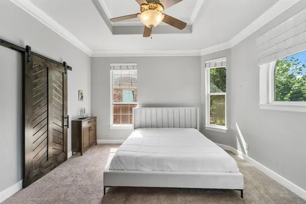 a large bedroom with a bed and a chandelier