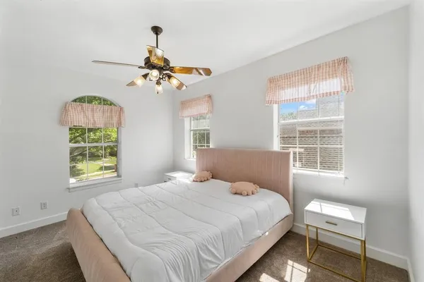 a bedroom with a bed chandelier and a window