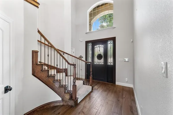 a view of hallway with wooden floor and stairs