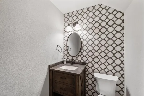a bathroom with a sink mirror and toilet