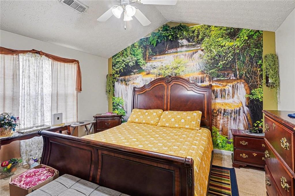 204 Hailey Lane Griffin, GA 30223 - Photo 15 of 32 a bedroom with a bed table flowerpot and window