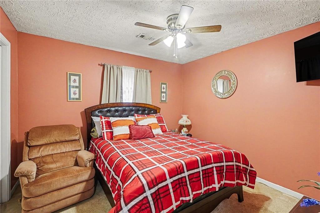 204 Hailey Lane Griffin, GA 30223 - Photo 22 of 32 a bedroom with a bed and a chandelier