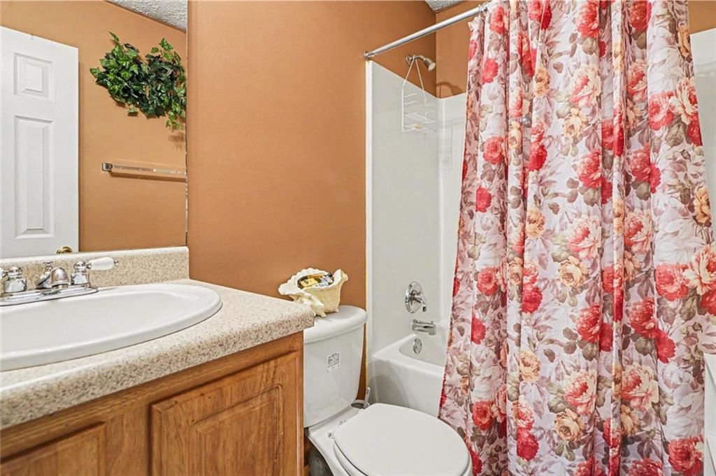 204 Hailey Lane Griffin, GA 30223 - Photo 24 of 32 a bathroom with a granite countertop sink and a toilet