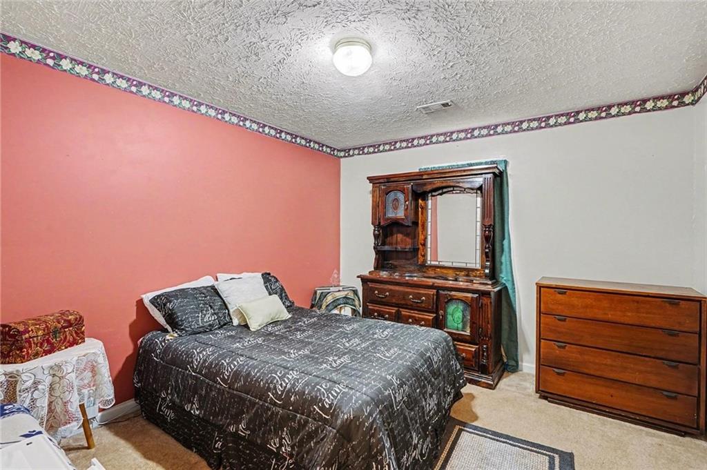 204 Hailey Lane Griffin, GA 30223 - Photo 25 of 32 a bedroom with a bed and dresser with mirror
