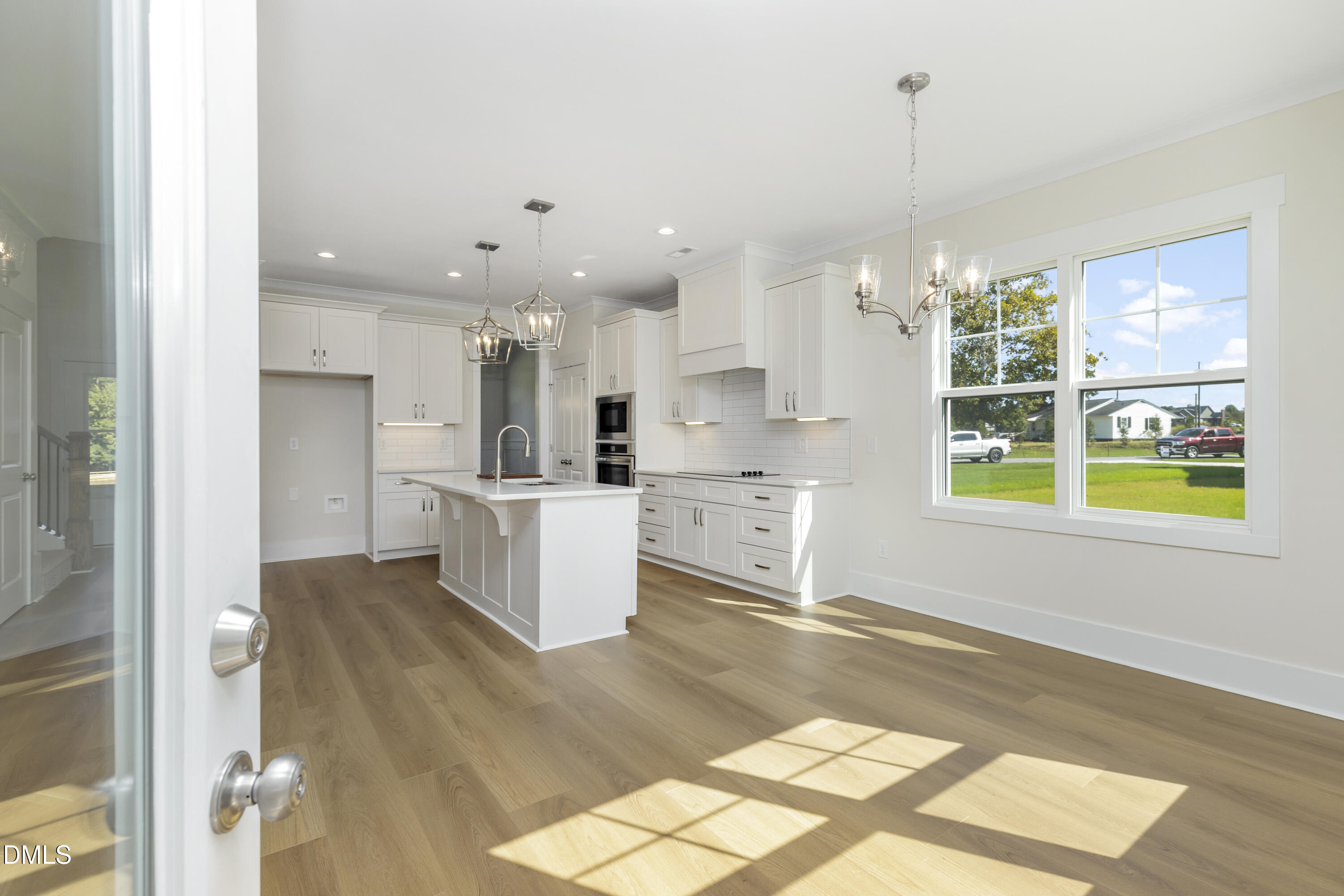 61 Croatoke Court Angier, NC 27501 - Photo 13 of 36 a kitchen with stainless steel appliances kitchen island granite countertop a refrigerator cabinets and wooden floor
