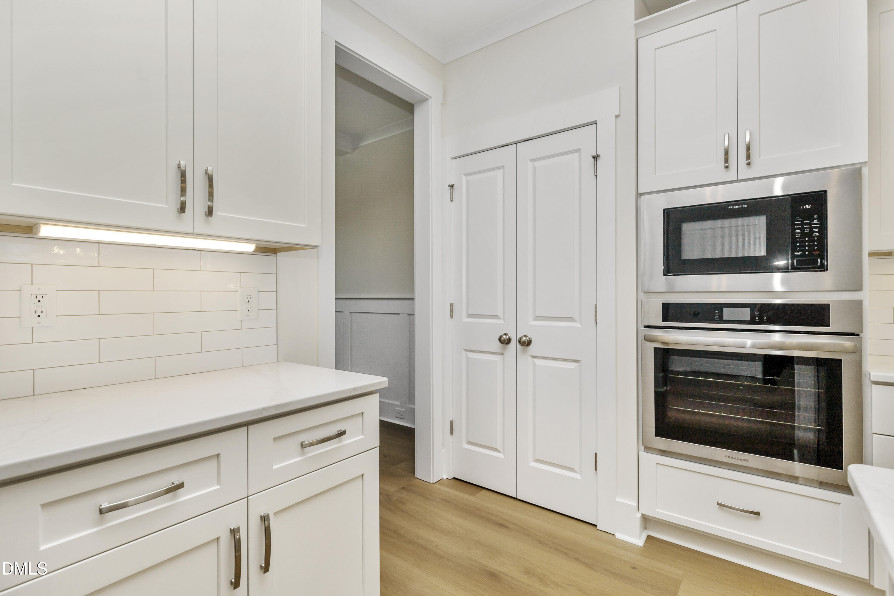 61 Croatoke Court Angier, NC 27501 - Photo 9 of 36 a kitchen with stainless steel appliances white cabinets and wooden floor