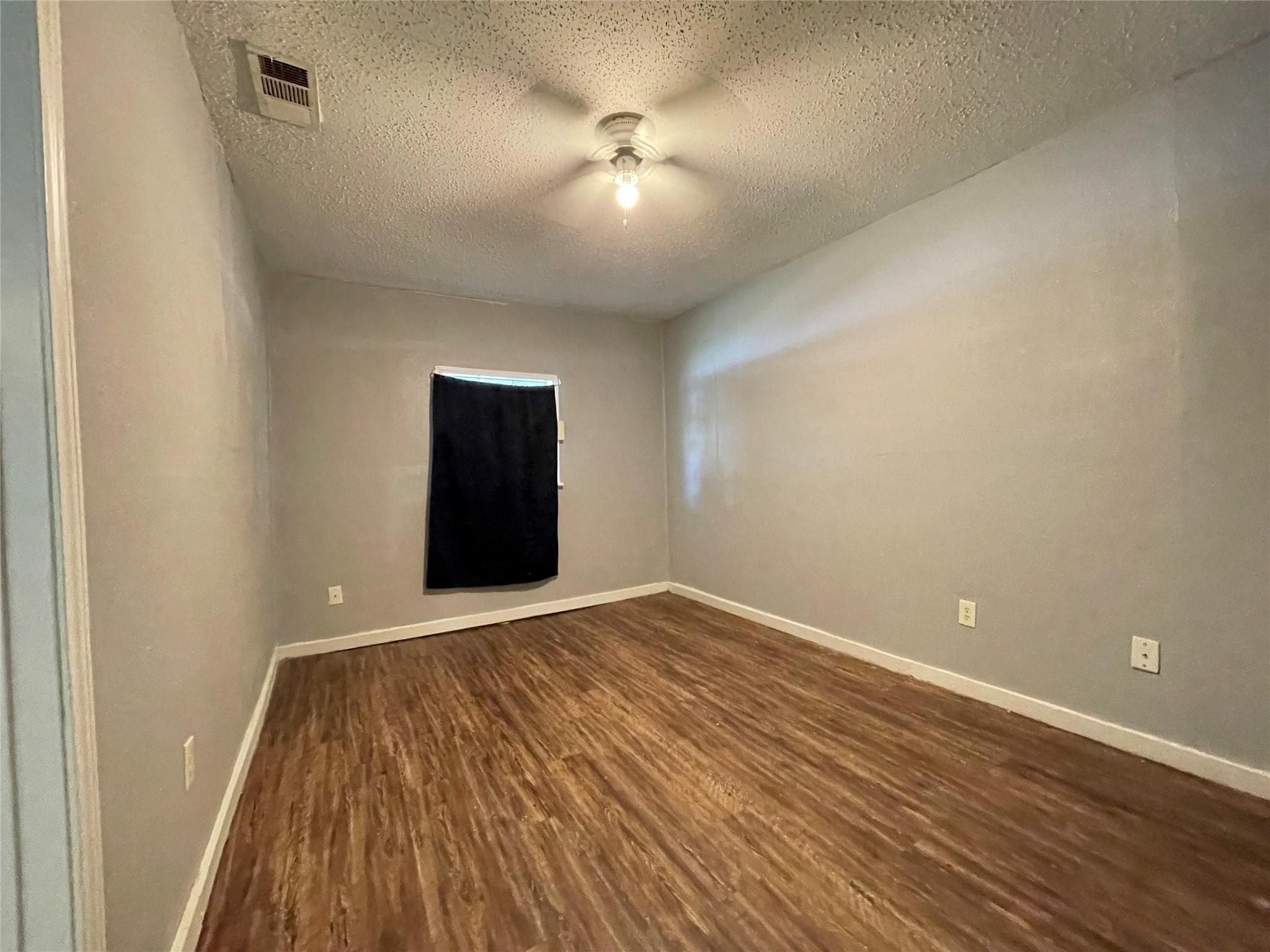 5213 Anzio Road Houston, TX 77033 - Photo 18 of 20 a view of an empty room with wooden floor