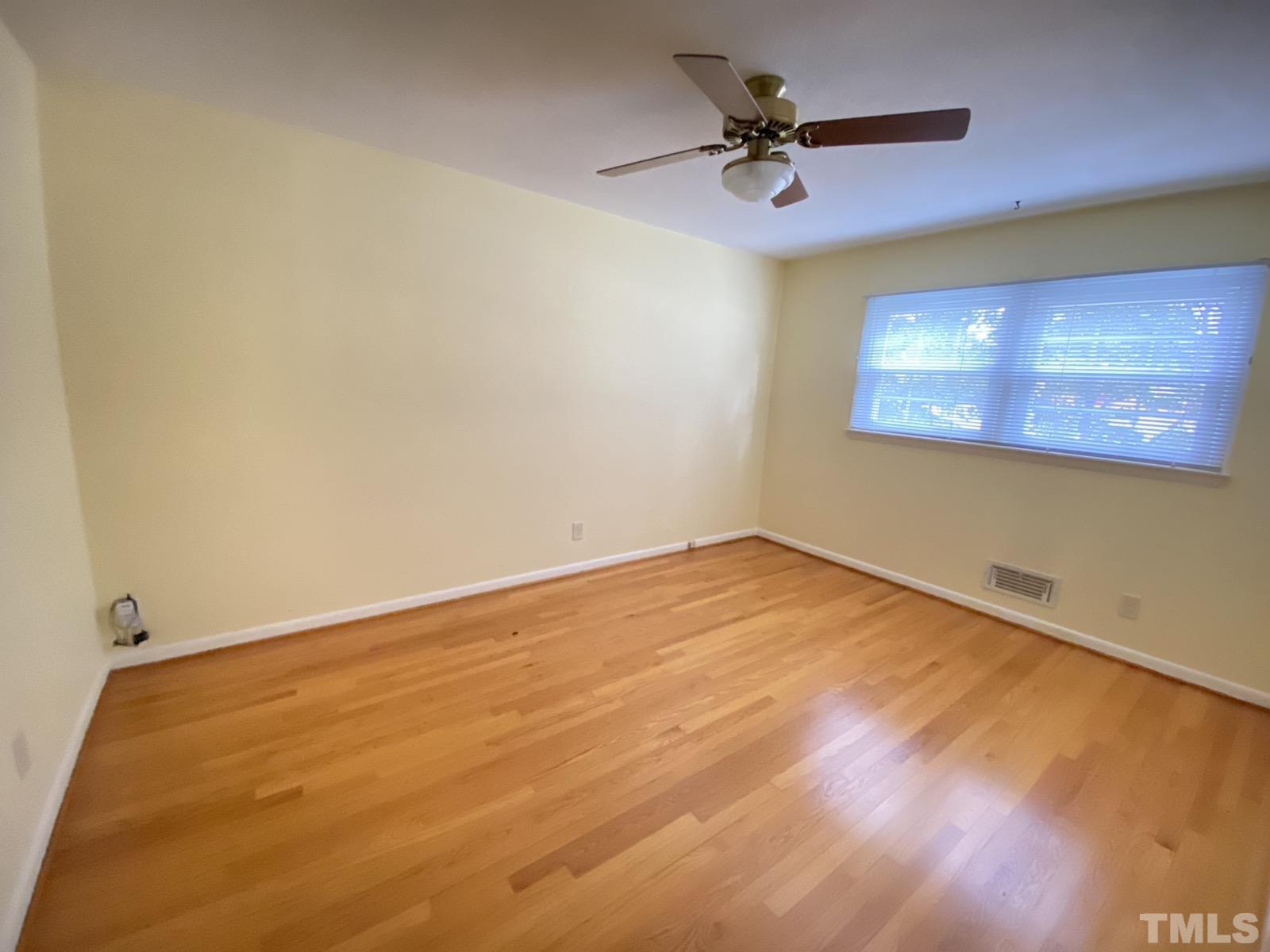711 Kildaire Farm Road Cary, NC 27511 - Photo 12 of 19 a view of empty room with a ceiling fan and wooden floor