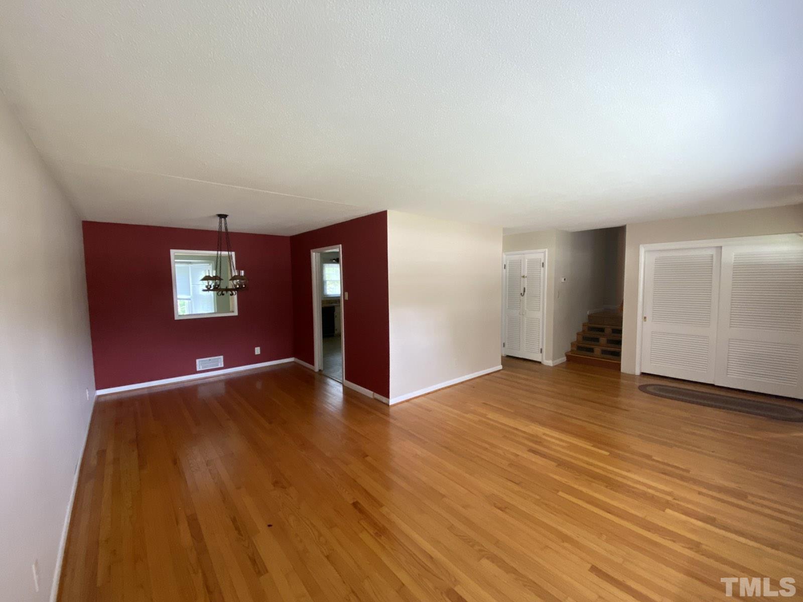 711 Kildaire Farm Road Cary, NC 27511 - Photo 3 of 19 a view of an empty room with wooden floor and windows