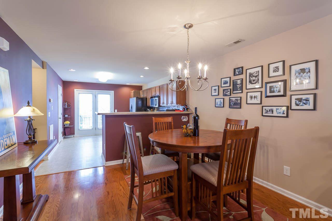 9909 Kedzie Court Raleigh, NC 27617 - Photo 11 of 22 a view of a dining room and livingroom with furniture wooden floor a rug a painting and a chandelier
