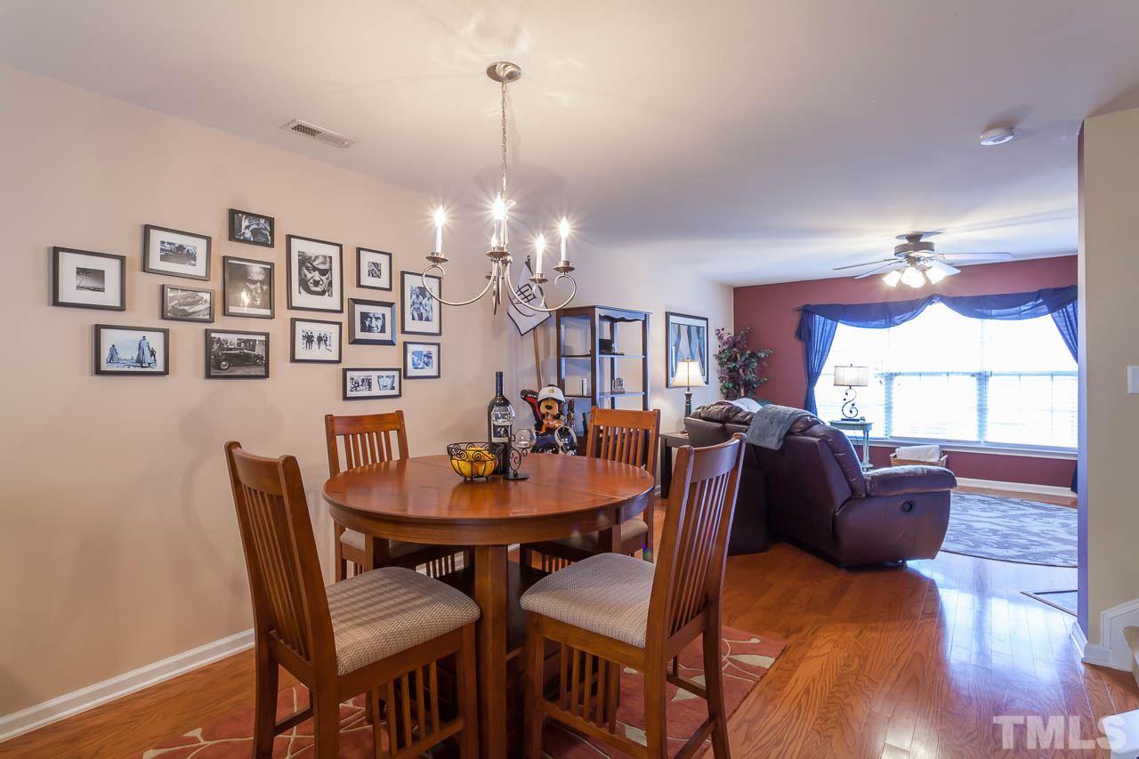9909 Kedzie Court Raleigh, NC 27617 - Photo 12 of 22 a view of a dining room with furniture a chandelier and wooden floor