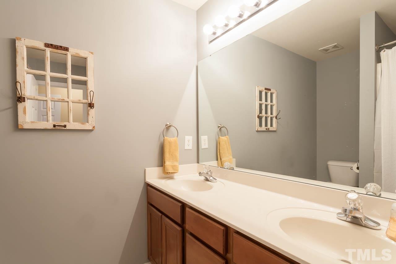9909 Kedzie Court Raleigh, NC 27617 - Photo 4 of 22 a bathroom with a sink and a mirror