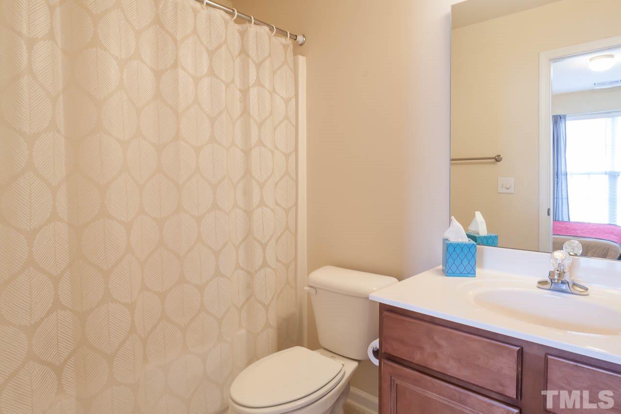 9909 Kedzie Court Raleigh, NC 27617 - Photo 5 of 22 a bathroom with a sink a toilet and a mirror