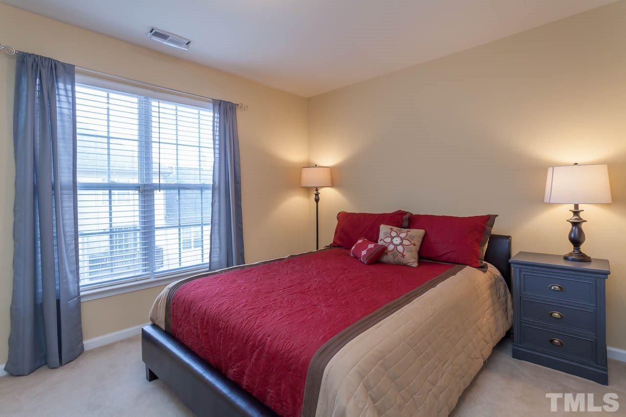 9909 Kedzie Court Raleigh, NC 27617 - Photo 6 of 22 a bedroom with a bed and a lamp