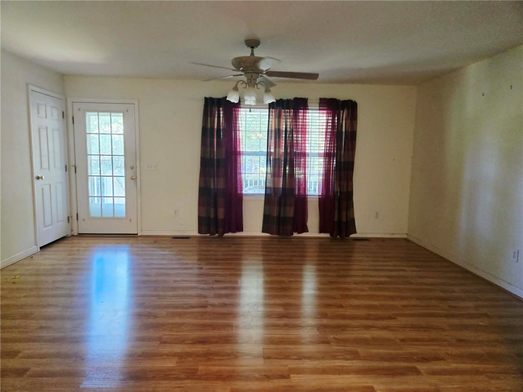 202 Keith Lane Seneca, SC 29678 - Photo 9 of 23 A versatile living area features durable wood flooring, ample natural illumination, and a glass-paneled entry door.