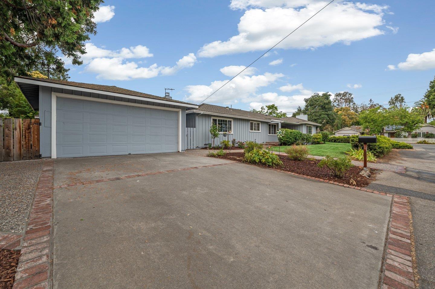 a view of an house with backyard and bushes