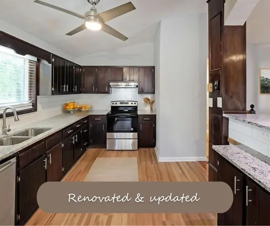 a kitchen with stainless steel appliances granite countertop a sink a stove top oven a counter space and cabinets