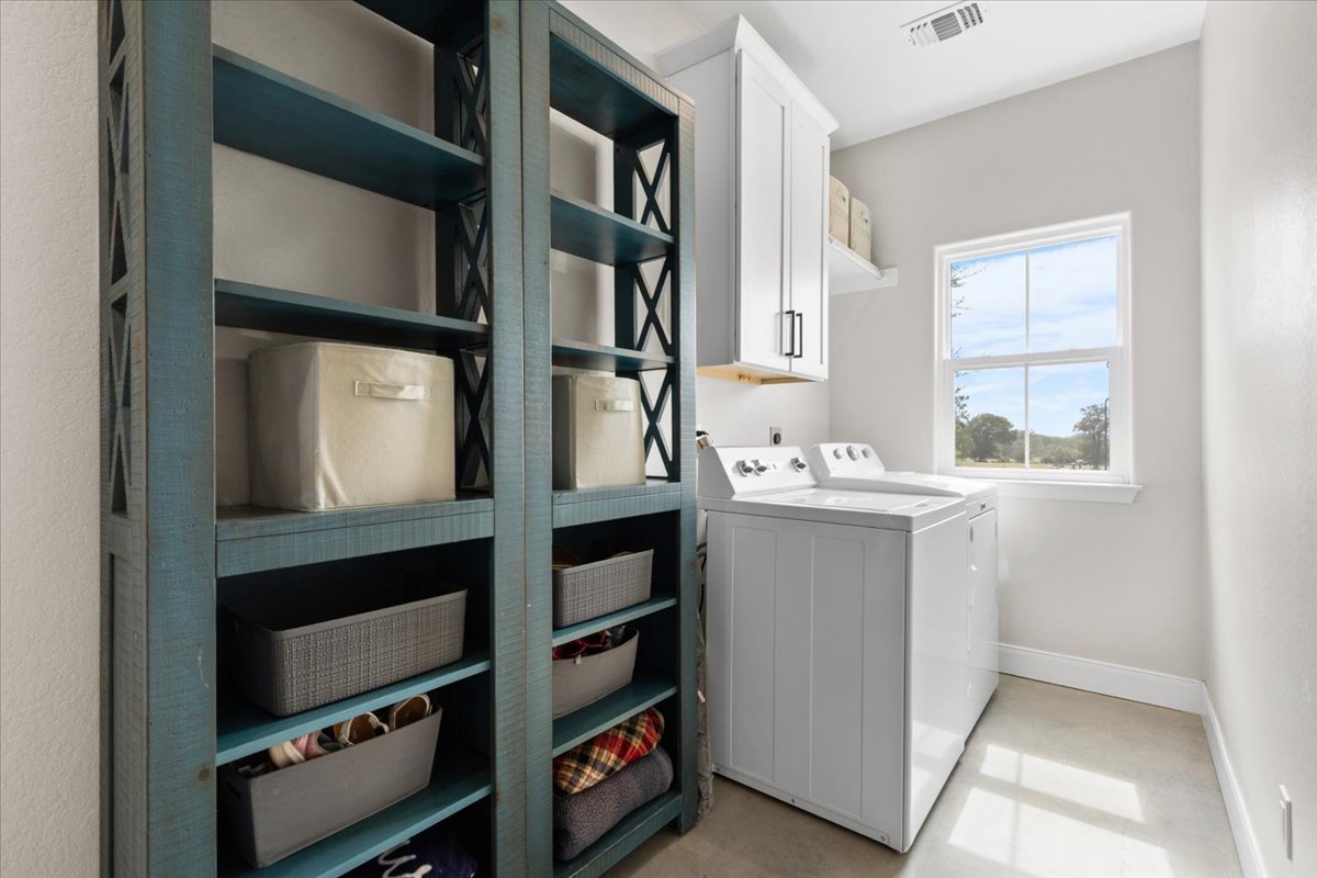 3389 Sparta Field Road Waelder, TX 78959 - Photo 22 of 40 Laundry room with cabinet space and washing machine and clothes dryer