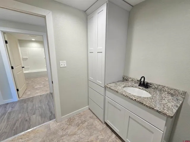 a bathroom with a granite countertop sink and a mirror