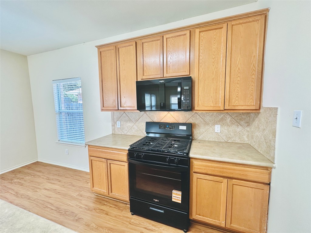 2205 Boyds Way Austin, TX 78748 - Photo 11 of 40 a kitchen with granite countertop wooden cabinets and a stove top oven